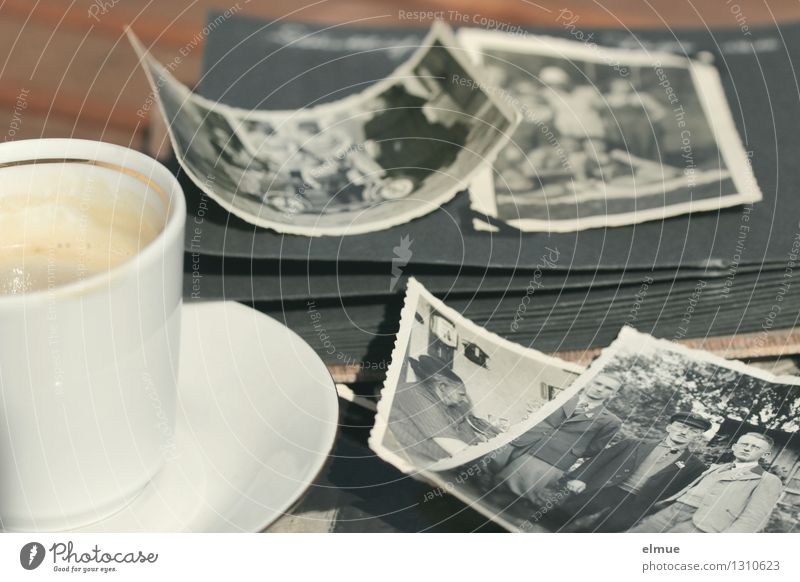 alte Papierbilder, altes Fotoalbum und eine kleine Tasse auf einem Tisch Espresso Fotografie Roman Erzählung historisch einzigartig Originalität Gefühle