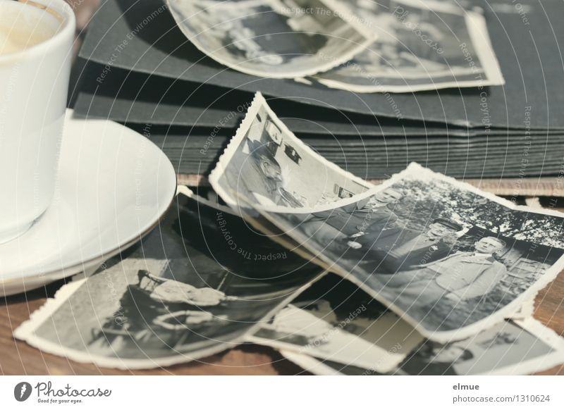 alte Papierbilder, altes Fotoalbum und eine kleine Tasse auf einem Tisch Espresso Fotografie Roman Erzählung Vergangenheit historisch einzigartig Originalität