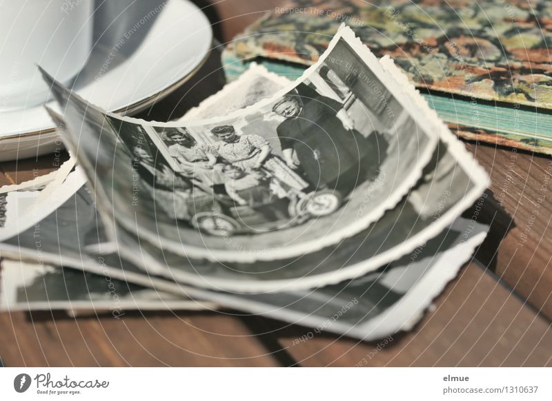 altes Poesiealbum , alte Papierbilder und eine kleine Tasse auf einem Holztisch Fotoalbum Fotografie Roman historisch einzigartig Originalität dankbar