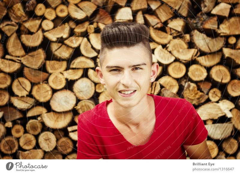 Portrait lächelnder Teenager vor Holzstapel Stil Freizeit & Hobby Sommer Kind Mensch Junger Mann Jugendliche 1 13-18 Jahre Natur Herbst Garten Mode