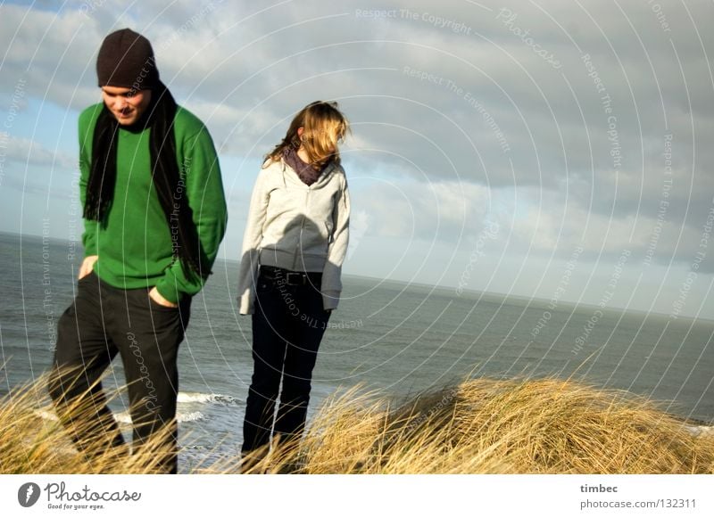 Wir zwei Mann Frau Meer Wolken schlechtes Wetter Strand grün grau Pullover Schal Mütze Bewegung gehen Gras Wind Trennung kalt Hand Hose dunkel Winter Mensch
