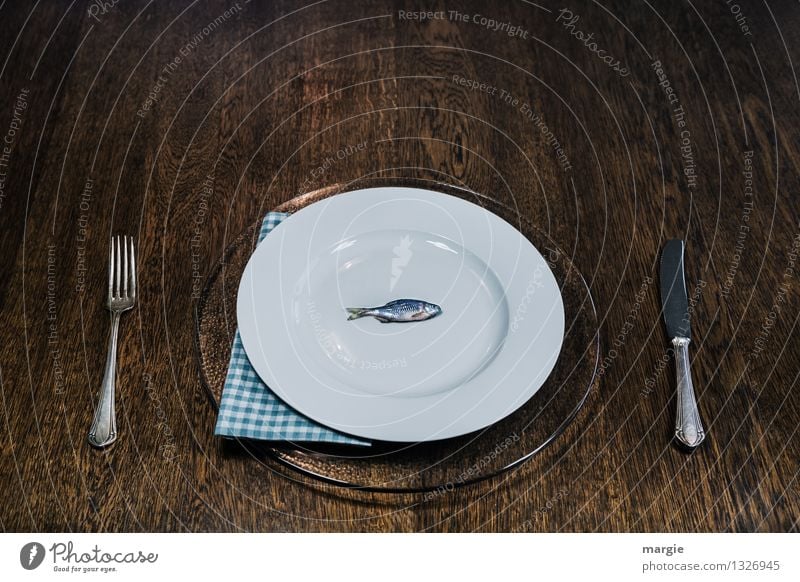 Fisch ist gesund: ein kleiner Fisch auf einem großen Teller mit Messer und Gabel und Serviette Lebensmittel Ernährung Mittagessen Abendessen Büffet Brunch