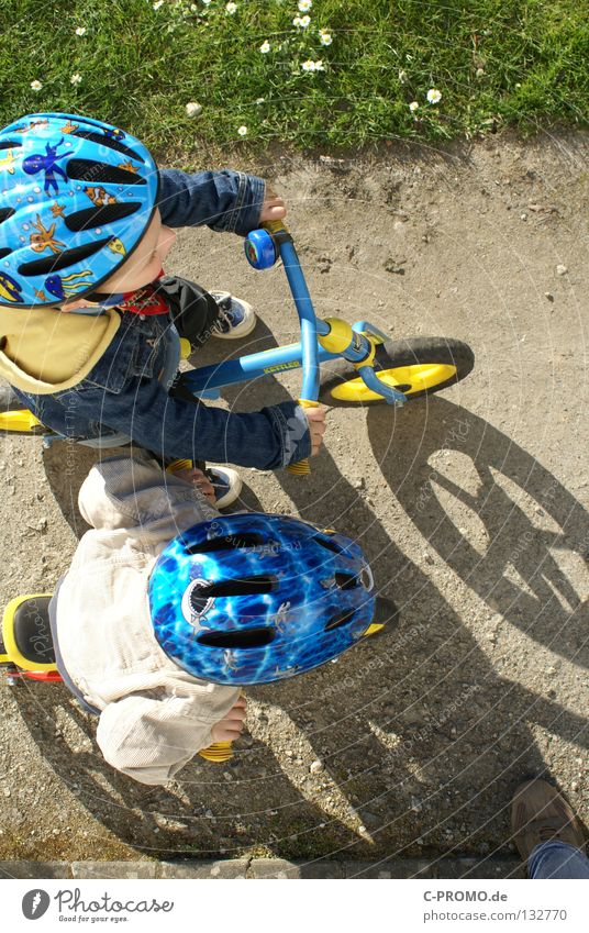 Auf die Plätze, fertig, los... Kind Helm Sicherheit Gegner Gras Wiese Vogelperspektive Spielen Sportveranstaltung Konkurrenz Funsport Fahrrad Schatten Beginn