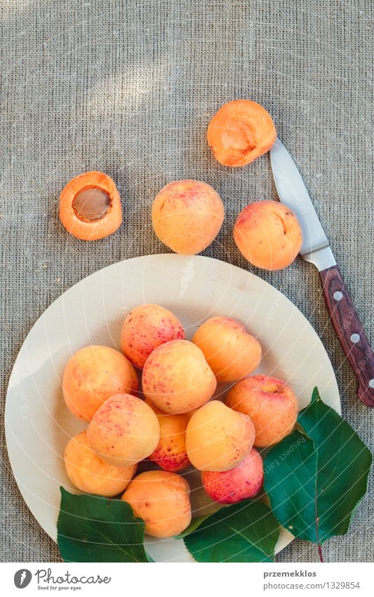 Frische Aprikosen gerade vom Garten auf hölzerner Platte Lebensmittel Frucht Bioprodukte Teller Sommer Natur frisch lecker süß gelb orange Gesundheit Leinen