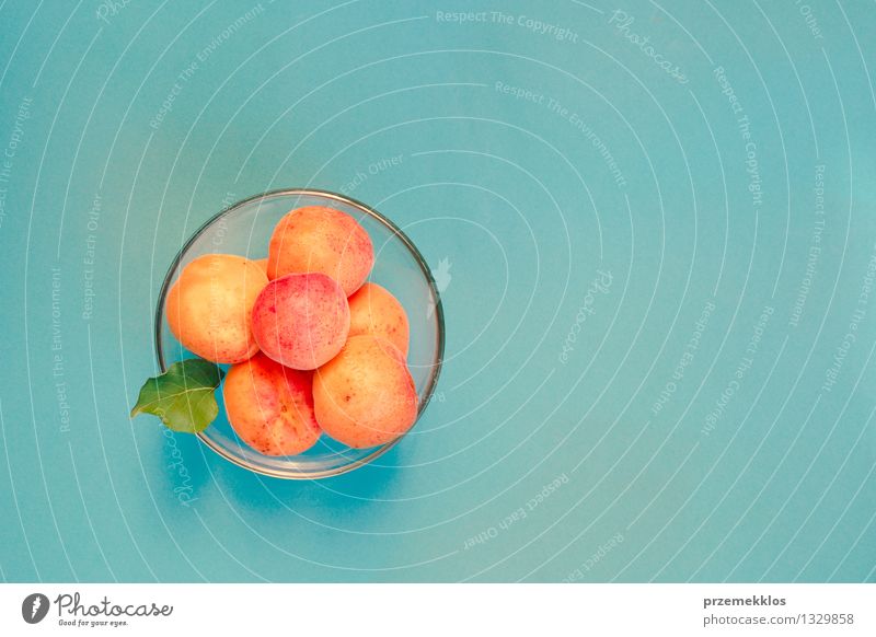 Aprikosen in der Schüssel auf blauem Hintergrund Lebensmittel Frucht Bioprodukte Schalen & Schüsseln Sommer Natur frisch lecker süß gelb orange Glaswaren