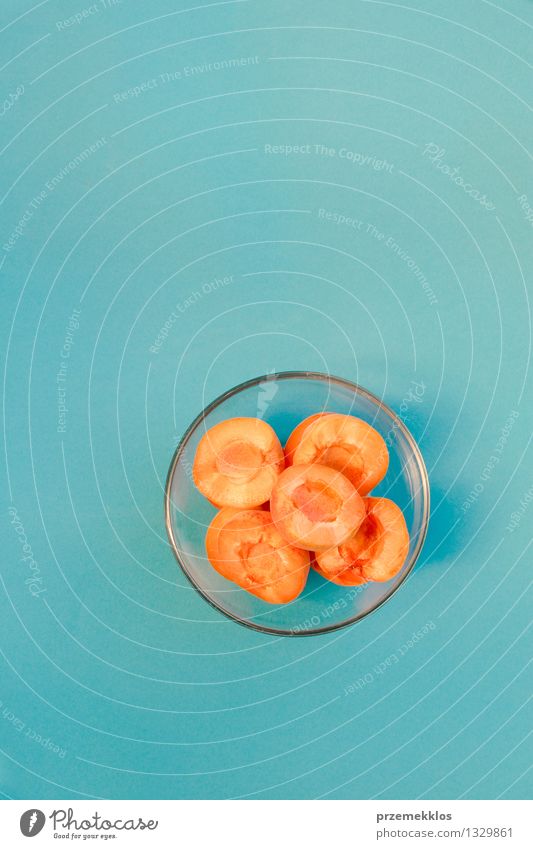 Geschnittene Aprikosen in der Schüssel auf blauem Hintergrund Frucht Schalen & Schüsseln Sommer Natur frisch hell orange Lebensmittel Glaswaren Gesundheit