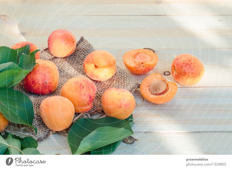 Frische Aprikosen gerade vom Garten auf Holztisch Lebensmittel Frucht Bioprodukte Sommer Tisch Natur Blatt frisch lecker natürlich gelb grün orange Gesundheit