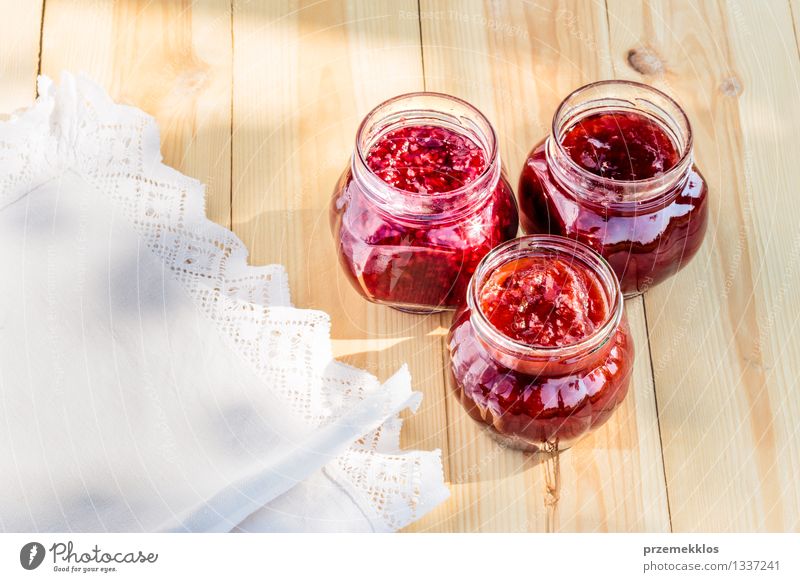 Hausgemachte Marmelade auf Holztisch Frucht Frühstück Bioprodukte Löffel Sommer Tisch Natur frisch lecker natürlich rot Tradition Lebensmittel Glas Gesundheit