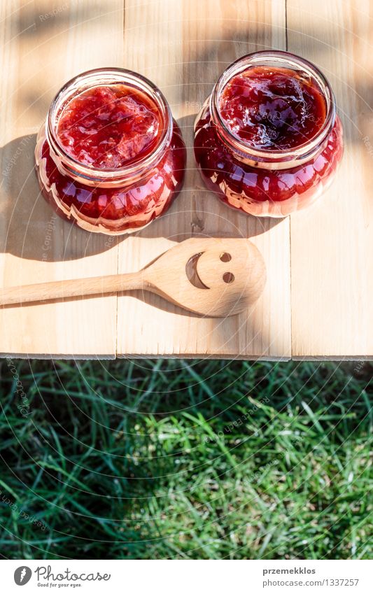 Hausgemachte Marmelade auf Holztisch Frucht Frühstück Löffel Sommer Tisch Natur Gras frisch lecker natürlich rot Tradition Lebensmittel Glas Gesundheit
