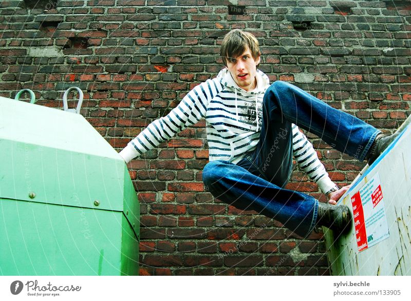 let´s go another way schön Mann Erwachsene Mauer Wand Jeanshose festhalten springen sportlich hoch oben grün Kraft gestreift Müllbehälter aufsteigen Halt