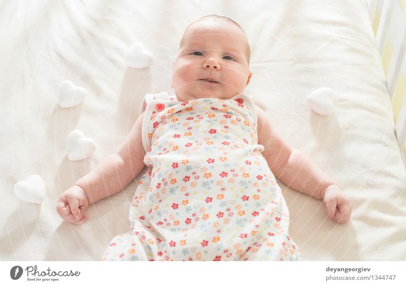 Baby in einem Babybett. Weiße Kleidung Glück Gesicht Leben Kind Mädchen Lächeln schlafen klein weich weiß Bett neugeboren lügen reizvoll Kaukasier heimwärts