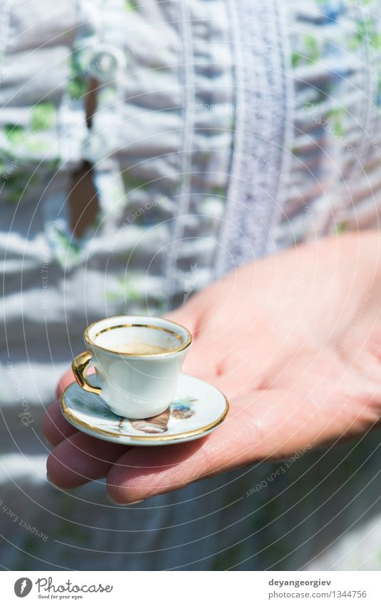 Hand halten sehr kleine Tasse Kaffee Stil Garten Tisch Frau Erwachsene heiß retro weiß Farbe Miniatur Café Halt Overhead altehrwürdig Untertasse Menschen