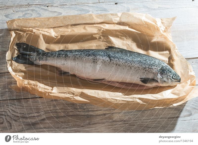Roher Fisch in Papier gewickelt Meeresfrüchte frisch Kreativität umhüllen Lebensmittel roh Mahlzeit Holz hölzern Schuppen Squama verhüllt Lachs Gesundheit