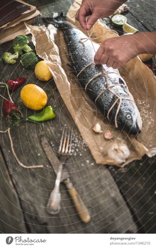 Ein Seil an Fische zum Grillen binden Meeresfrüchte Gemüse Abendessen Tisch Koch Hand Papier dunkel frisch lecker schwarz kochen & garen roh Zutaten Mahlzeit