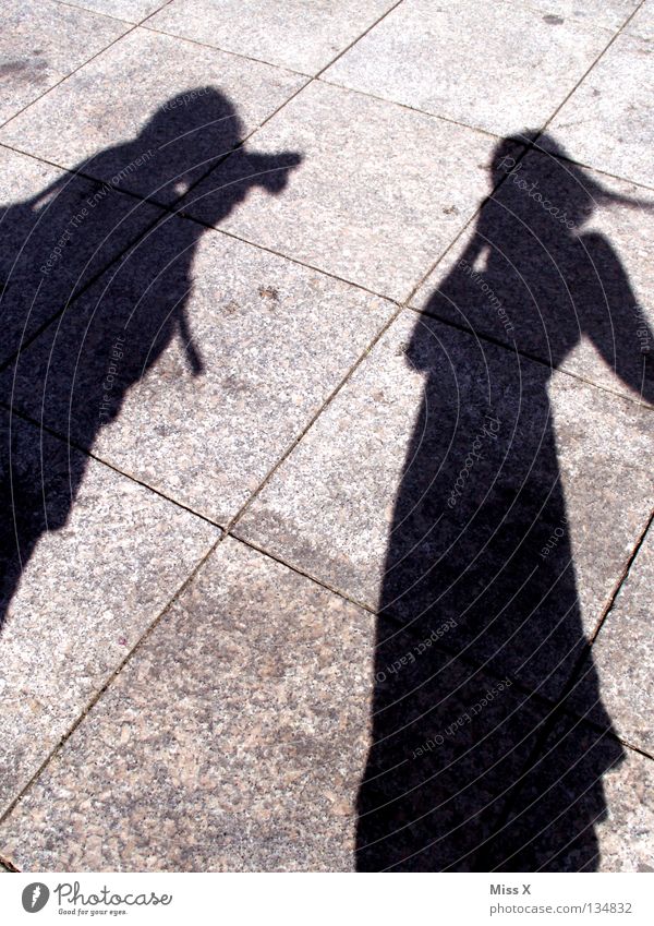 Scheiß Paparazzi Farbfoto Schwarzweißfoto Außenaufnahme Schatten Silhouette Mensch Frau Erwachsene Mann Beine Straße grau schwarz Asphalt steinig unterwegs