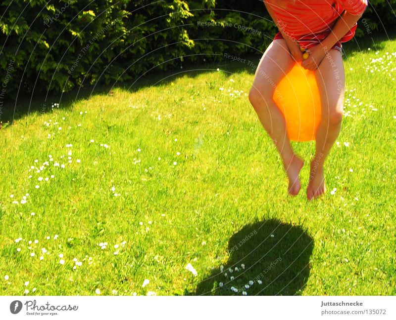 Känguruh Kind Junge Spielen Spielzeug hüpfen springen gelb grün Wiese Gras Sport Freude Hüpfball Känguruhball Garten Rasen lustig Schatten hoch Lausejunge