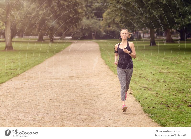 Athletische Frau, die in einem Park trainiert Sommer Sport Joggen Erwachsene Natur Tatkraft Aktion sportlich Herz Textfreiraum üben Gesundheit Jogger Läufer