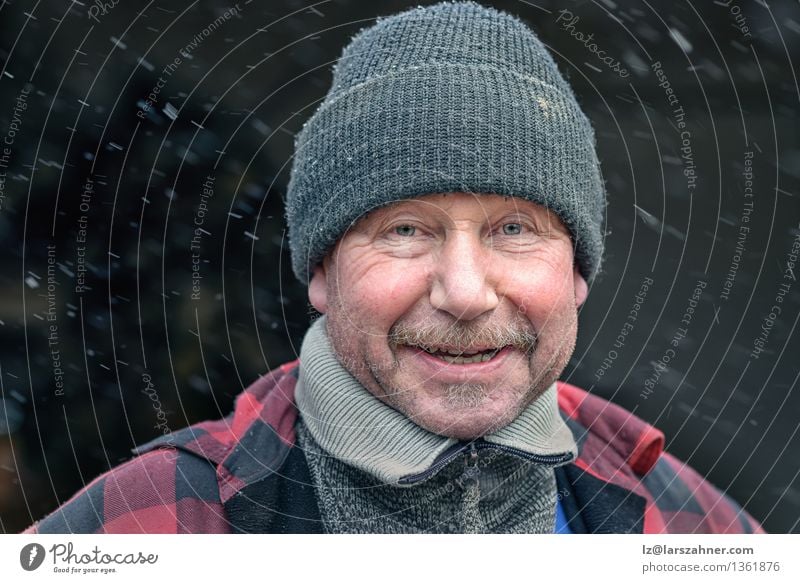 Glücklicher Mann mit Schnurrbart in einer gestrickten Wintermütze und warmer Winterkleidung Gesicht Schnee Handwerker Erwachsene Wetter Mode Jacke Hut