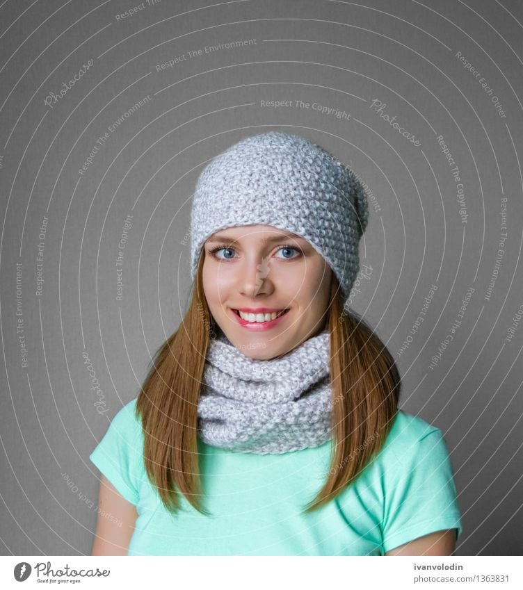 Lächelndes junges Mädchen in der Winterkappe und -schal Freude Glück schön Haut Gesicht Kosmetik Mensch Frau Erwachsene Wärme Mode Bekleidung Pullover Schal
