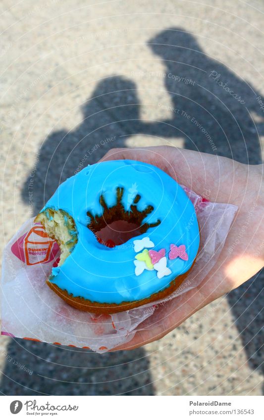 Donut in der Hand Krapfen lecker mehrfarbig Kuchen Backwaren Süßkram Freie Zeit Schattenpiel Glasur