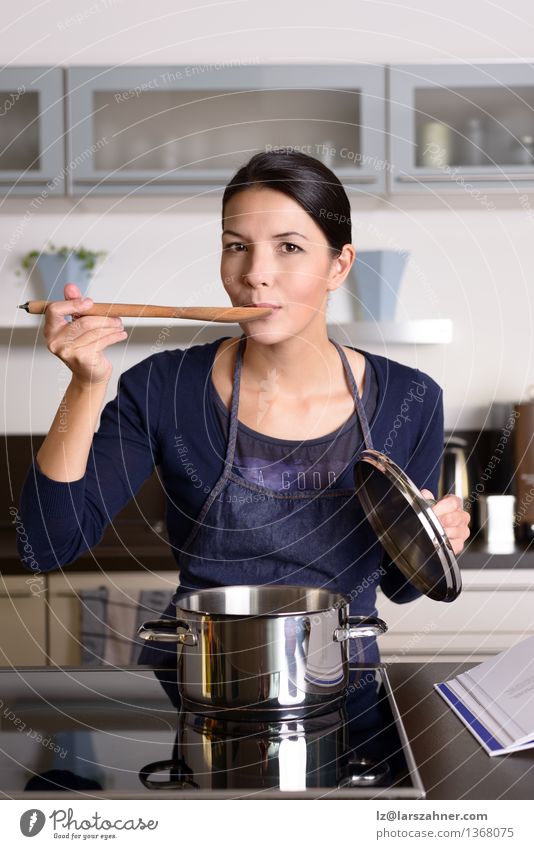Junge Hausfrau, die ihr Kochen schmeckt Abendessen Topf Löffel Lifestyle Gesicht Küche Frau Erwachsene 1 Mensch 30-45 Jahre Lächeln Glück Kontrolle Lebensmittel
