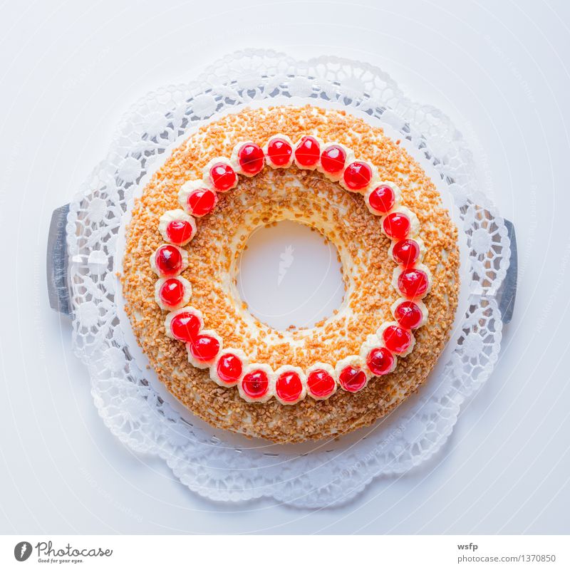 Frankfurter Kranz mit Kirschen auf weißem Hintergrund Kuchen Dessert Buttercremetorte ringförmig kranzförmig Schaumgebäck Sahne Torte Tortenspitze Backwaren