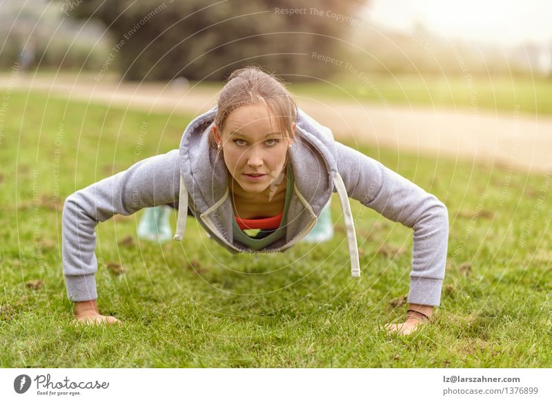 Das athletische Handeln der jungen Frau drückt Übungen hoch Lifestyle Glück Körper Gesicht Erwachsene Natur Gras Park Fitness dünn nah Athlet sportlich