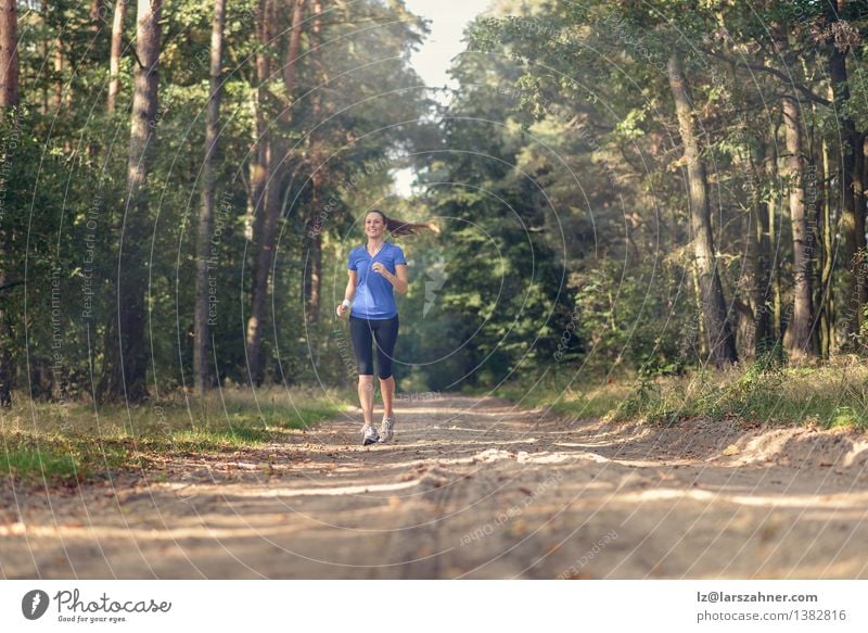 Athletische Frau, die heraus in einem Wald rüttelt Lifestyle Körper Sport Joggen Mädchen Erwachsene 1 Mensch 18-30 Jahre Jugendliche Natur Landschaft Sand
