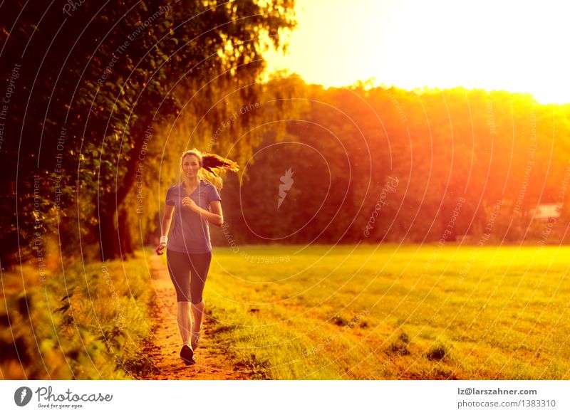 Junge Frau, die entlang einer Landspur rüttelt Lifestyle Gesicht Sommer Sport Joggen Erwachsene Gras Blatt Wege & Pfade Fitness grün Tatkraft Einsamkeit