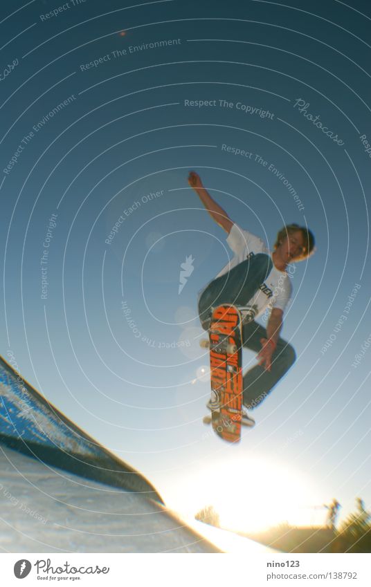 Grab Trick Stil Sport Spielen Funsport Sommer Leonidas Sonne blau Himmel Skateboarding orange Coolness