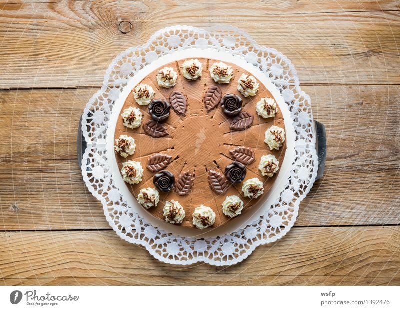 Schokosahnetorte auf rustikal Holz mit Tortenspitze Kuchen Dessert Schokolade süß Schokoladen-Sahne-Torte Schaumgebäck Backwaren Biskuit Holztisch Landhaus
