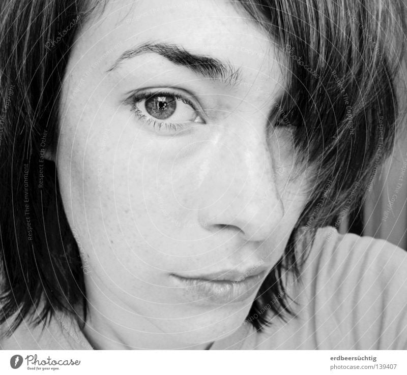 Porträt einer jungen Frau mit dunklen Haaren, Pony über einem Auge, das andere blickt intensiv in die Kamera Haare & Frisuren Haut Gesicht Erwachsene Nase Mund
