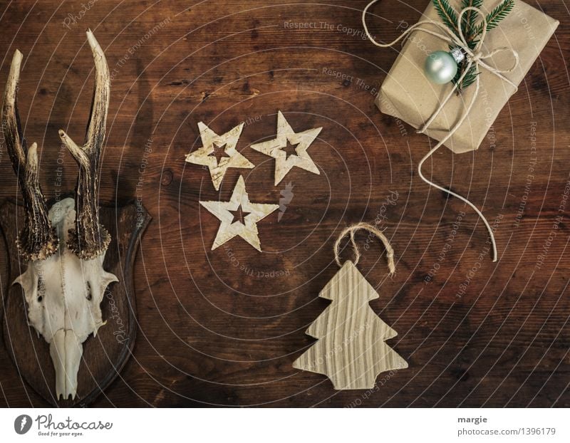 Frohe Weihnachten! Ein Geschenk, drei Sterne ein Weihnachtsbaum - Anhänger und ein Geweih hängen an einer Holzwand Freizeit & Hobby Häusliches Leben