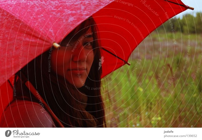 Bln 08 | es regnet... Frau Jugendliche feminin Lebewesen Regenschirm nass feucht schlechtes Wetter Freundlichkeit sympathisch Wiese Gras Brachland grün rot
