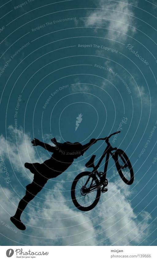 Superman Fahrrad springen Trick Stunt Show Wolken Mann Motorradfahrer Mountainbike gewagt Risiko Luft stehen gefährlich türkis Sommer Vogel schwarz Verlauf üben