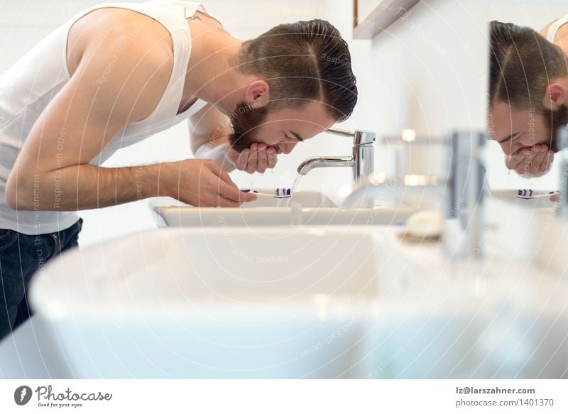 Mann spült seine Zahnbürste unter fließendem Wasser Gesicht Bad Erwachsene Vollbart Sauberkeit bürstend Pflege Kaukasier Textfreiraum Wasserhahn fertig machend