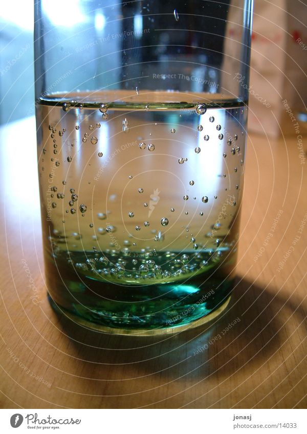 Natürlich Mineralwasser sprudelnd trinken ruhig Licht Glas Wasser Schatten Luftblase Holztisch Detailaufnahme Nahaufnahme rund Reflexion & Spiegelung