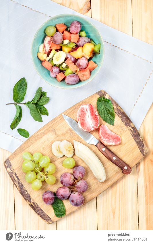 Salat mit frischen Früchten Lebensmittel Gemüse Frucht Ernährung Mittagessen Bioprodukte Vegetarische Ernährung Diät Schalen & Schüsseln Messer Tisch einfach
