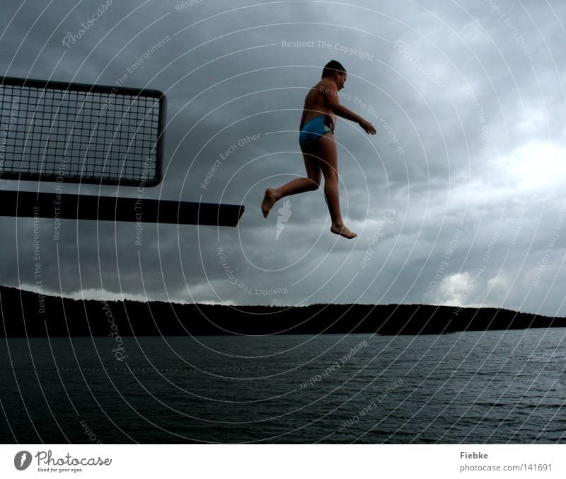 Jumper springen Sprungbrett Junge Kind schreiten Luft Regen grau Unwetter Wolken See Schwimmbad Freibad Badeort Schwimmen & Baden hüpfen Himmel schwarz Wasser