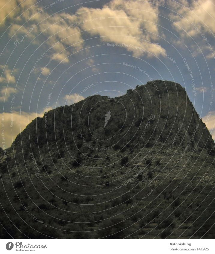 The Rock Berge u. Gebirge Pflanze Himmel Wolken Felsen Stein dunkel grau Spanien Kontrast steil Steilwand Menschenleer Landschaft Wolkenhimmel karg