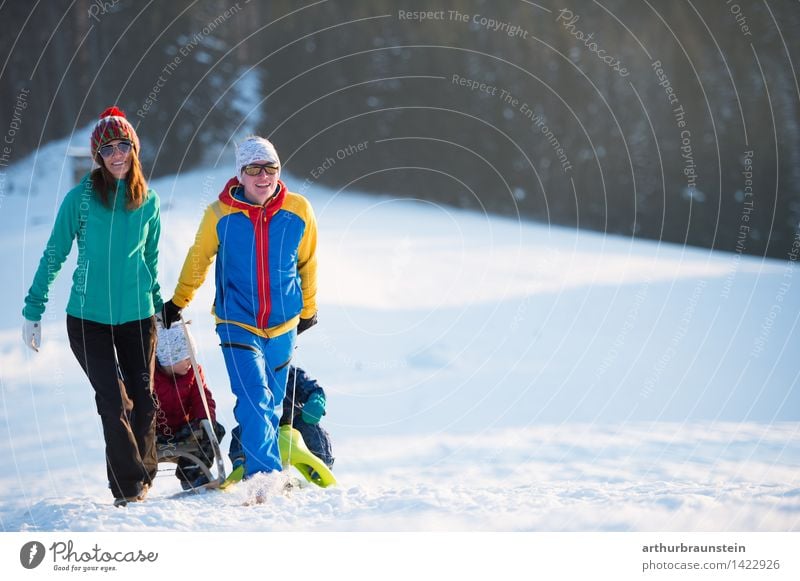 Junge Familie mit Kindern gehen Schlittenfahren im Winter bei Sonnenschein Freizeit & Hobby Ferien & Urlaub & Reisen Tourismus Ausflug Schnee Winterurlaub