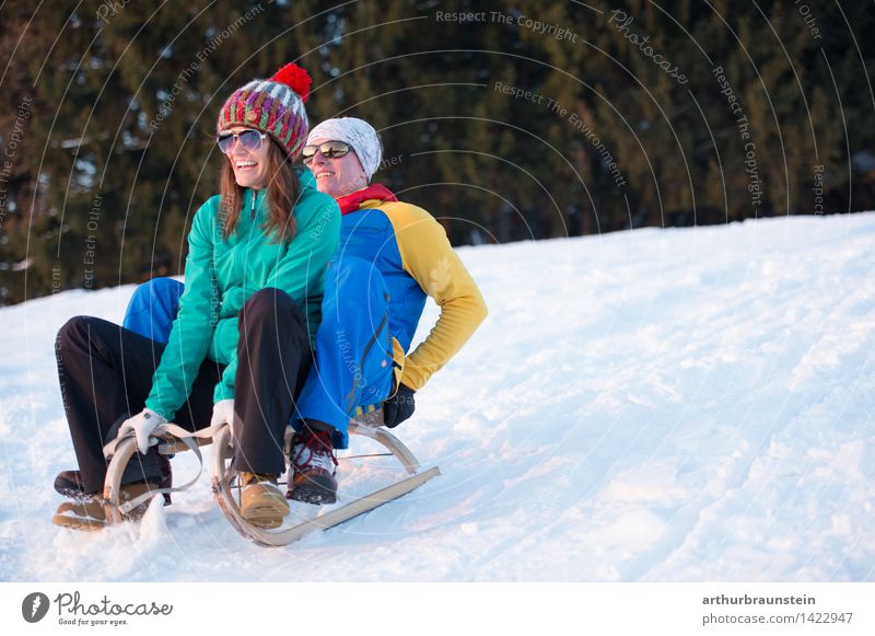 Junges Paar beim Schlittenfahren Freude Freizeit & Hobby Winter Schnee Winterurlaub Wintersport Skipiste Mensch maskulin feminin Junge Frau Jugendliche