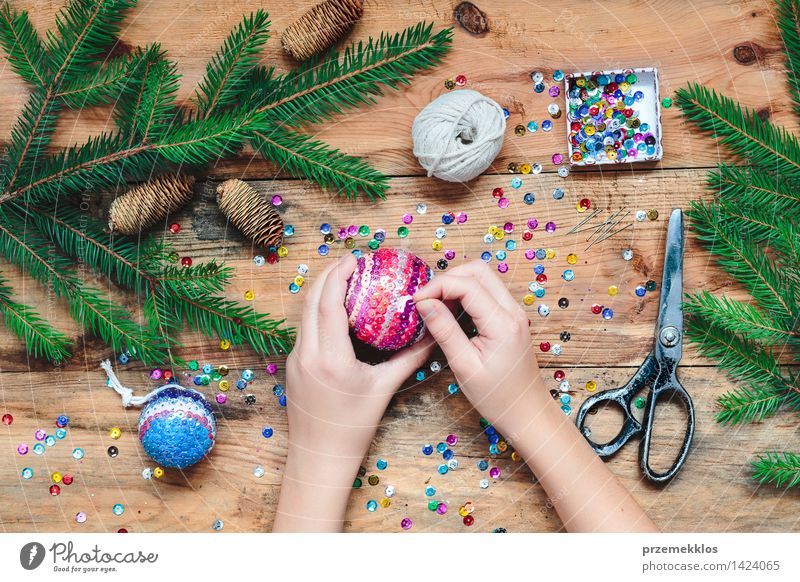 Mädchen, das Weihnachtsball macht, der die Paillette auf den Ball feststeckt Handarbeit Dekoration & Verzierung Tisch Schere 1 Mensch Holz Ornament Kreativität