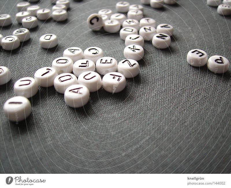 Durcheinander Lateinisches Alphabet Buchstaben Großbuchstabe weiß schwarz grau rund Wort Gedanke Schriftzeichen obskur Letter Perle Buchstabenperlen schreiben
