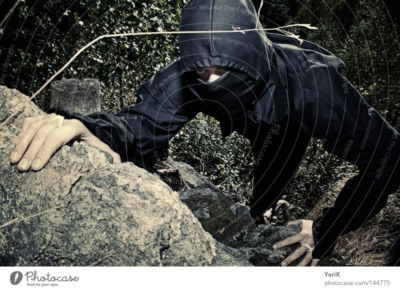 lautloser killer Ninja Söldner Mann vermummen Tarnung Kapuze schwarz dunkel Filmindustrie Japan Asien Blick grün braun gefährlich böse Bösewicht Täuschung