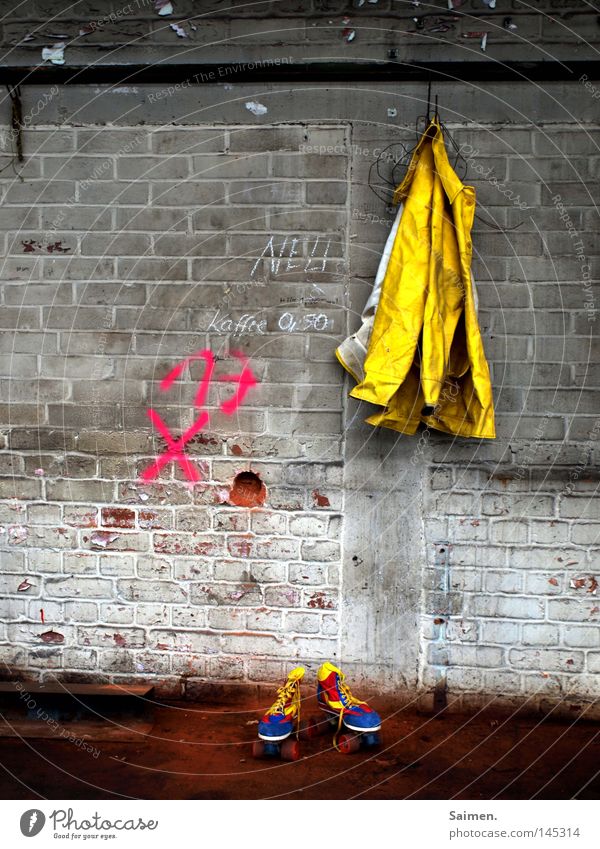 Freud und Leid Regenmantel Rollschuhe dreckig Stein Lagerhalle Halle schäbig Kontrast Gegenteil kalt nass mehrfarbig gelb rot blau Wand Boden aufhängen Fabrik