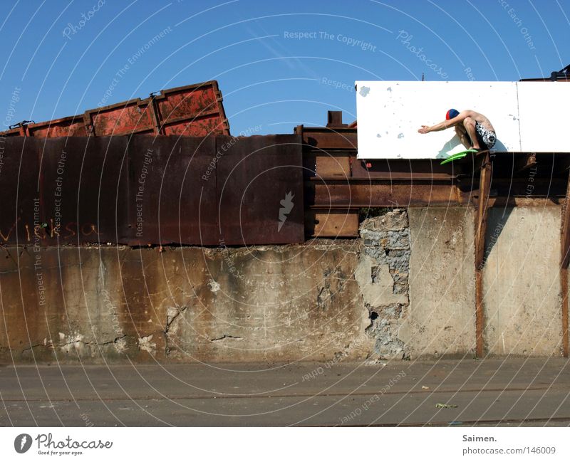 Haubentaucher Außenaufnahme Freude Freiheit Mann Erwachsene Himmel Mauer Wand Container Rost hocken frei trocken Mut Schmerz Einsamkeit Konzentration