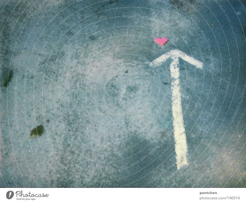 Ein weißer Pfeil zeigt auf ein kleines rotes Herz aus Plastik. Romantik, Kitsch, liebe. Wegweiser Valentinstag Zeichen Verkehrszeichen Verliebtheit Boden
