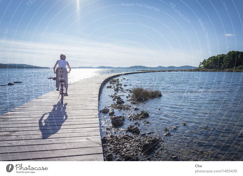 Übers Wasser feminin 1 Mensch 18-30 Jahre Jugendliche Erwachsene fahren Fahrrad Kindersitz Familie & Verwandtschaft Anlegestelle See Meer Biken Fahrradtour