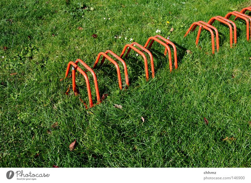 Radständer Fahrradständer Rasen Wiese rot grün diagonal Reihe Ordnung stellen parken Detailaufnahme Spielen Verkehr mehrere Örtlichkeit